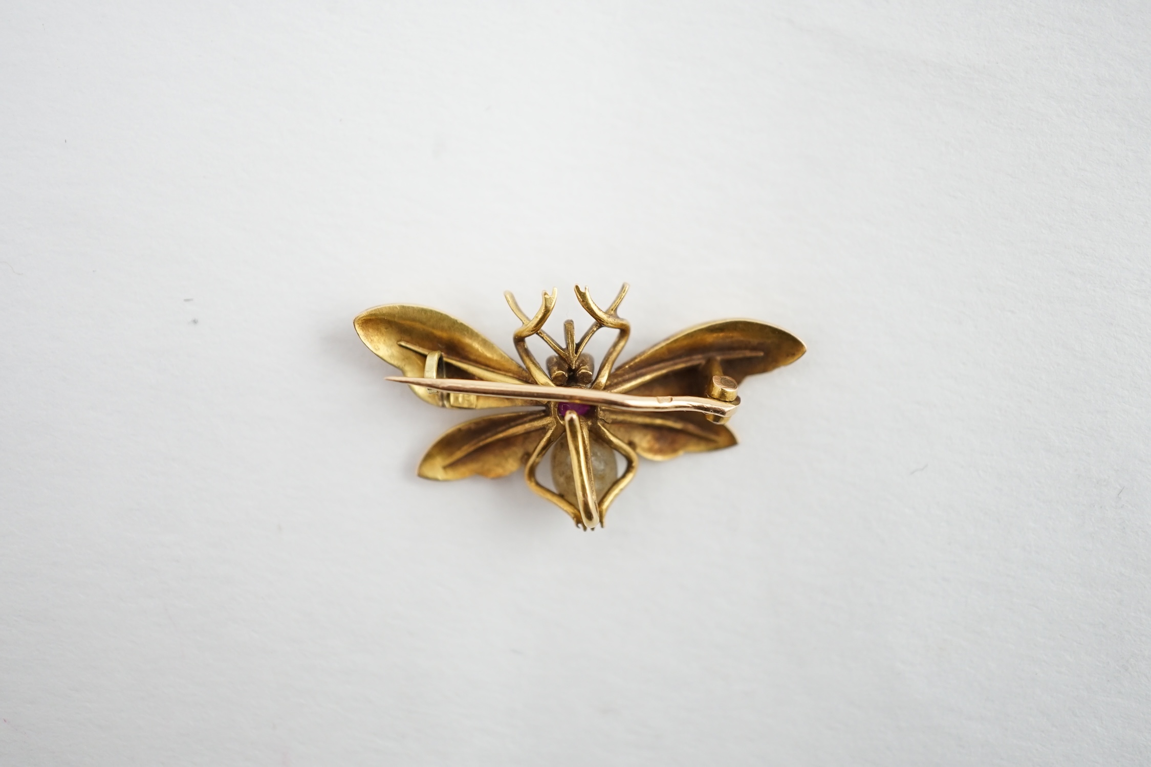 An early 20th century gold (stamped 18), ruby and baroque pearl set bug brooch